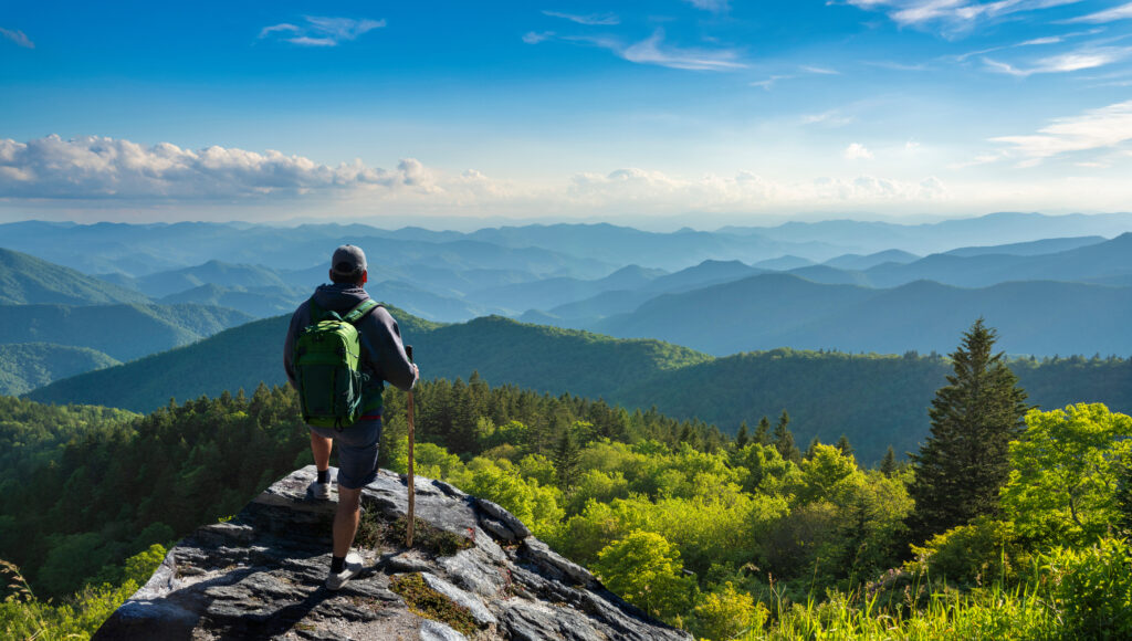 Man relaxing on hiking trip. Man hiker  standing  on top of the